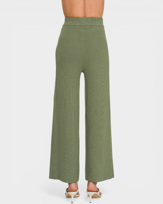 Green wide-leg pants worn by a person on a white background