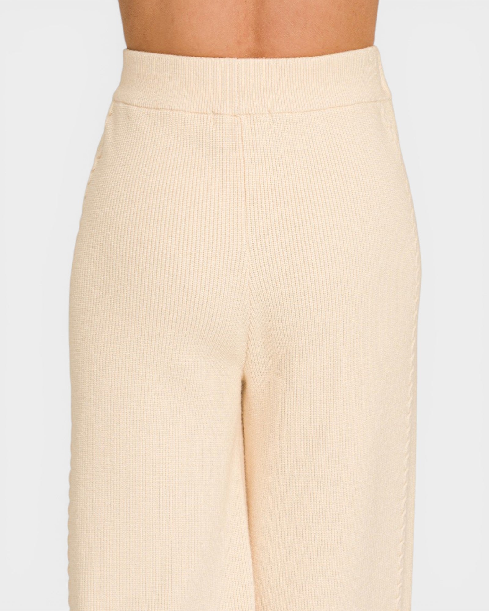 Beige ribbed pants on a plain background