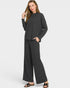 Woman wearing a black outfit with wide-leg pants on a white background