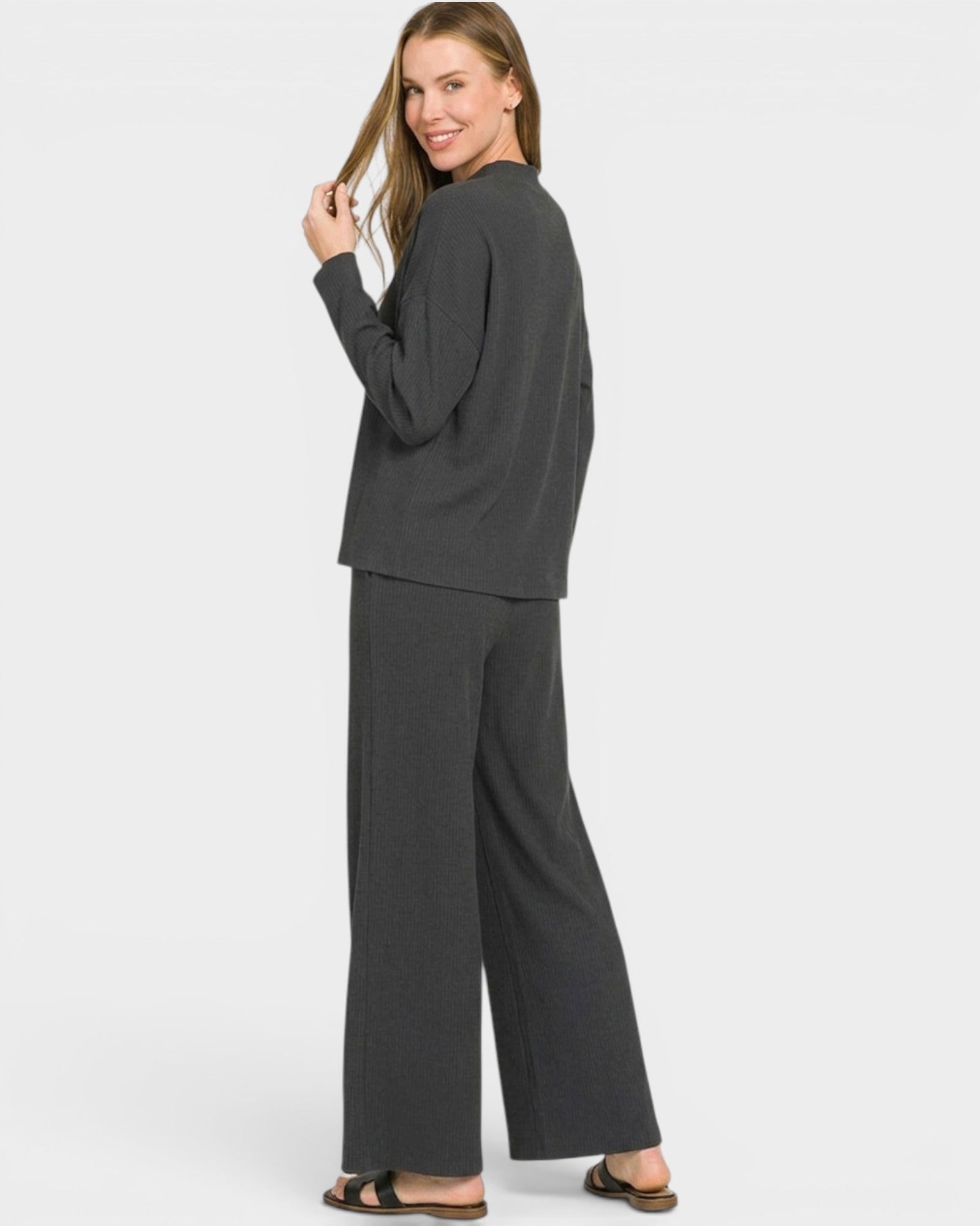 Woman wearing a black lounge set on a white background