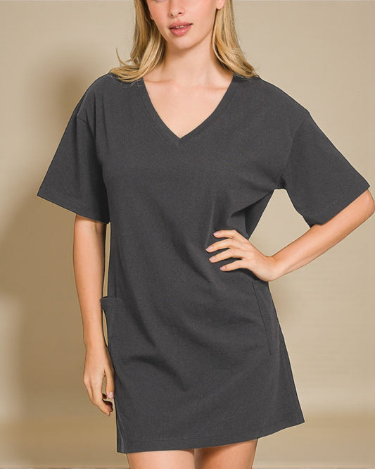 Woman wearing a dark gray t-shirt dress against a beige background