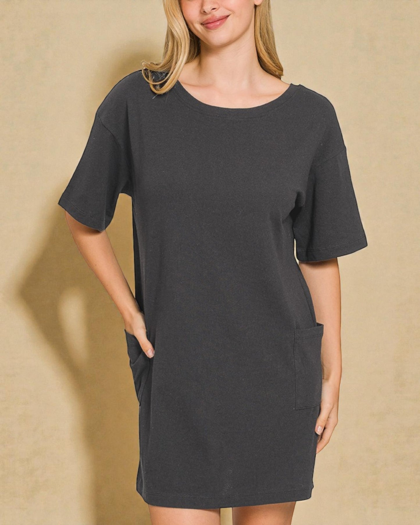 Woman wearing a dark gray t-shirt dress against a beige background