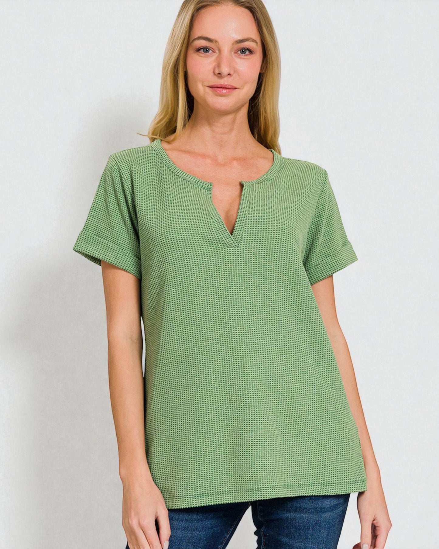 Woman wearing a green textured top against a white background
