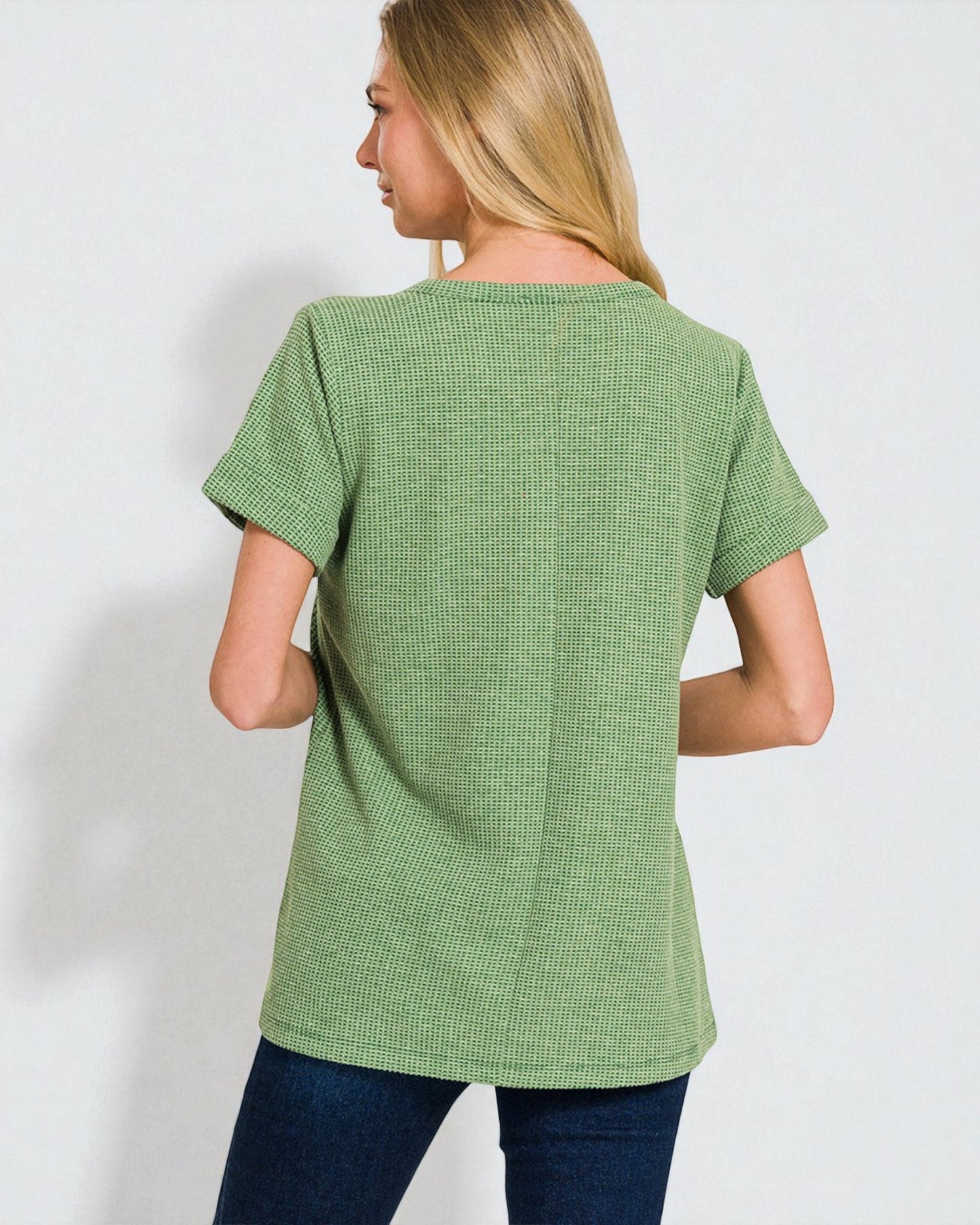Woman wearing a green textured t-shirt against a white background