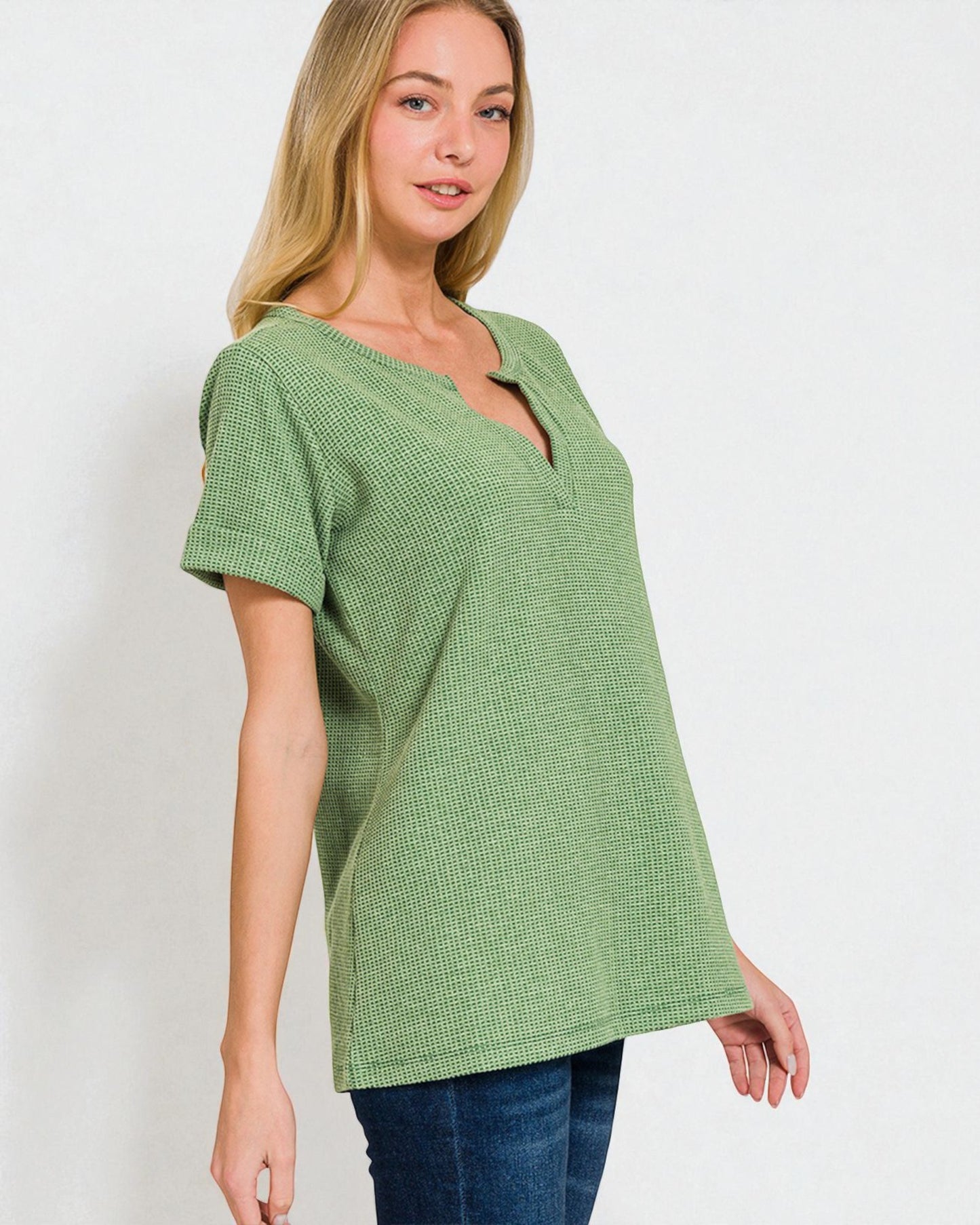 Woman wearing a green textured top against a white background