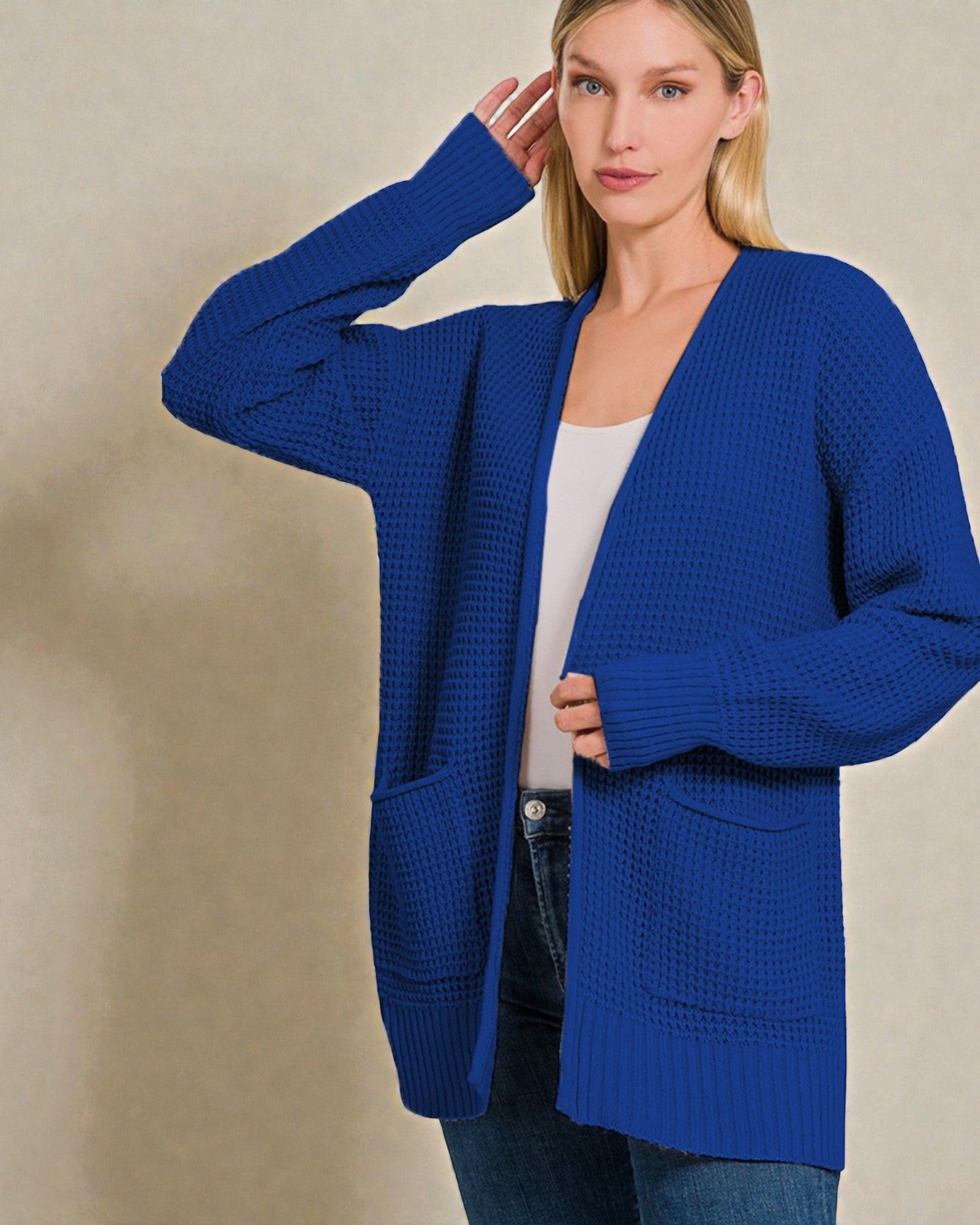 Woman wearing a blue cardigan against a beige background