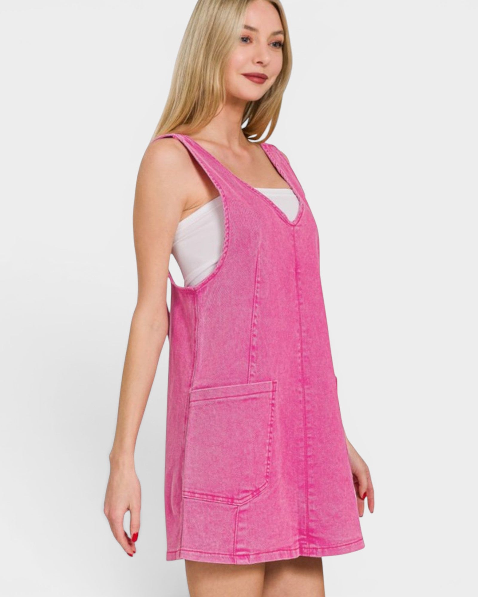 Woman wearing a pink denim dress against a white background