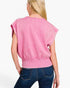 A woman shown from the back wearing a pink cropped short-sleeve top with a ribbed hem and blue jeans, against a plain white studio background.