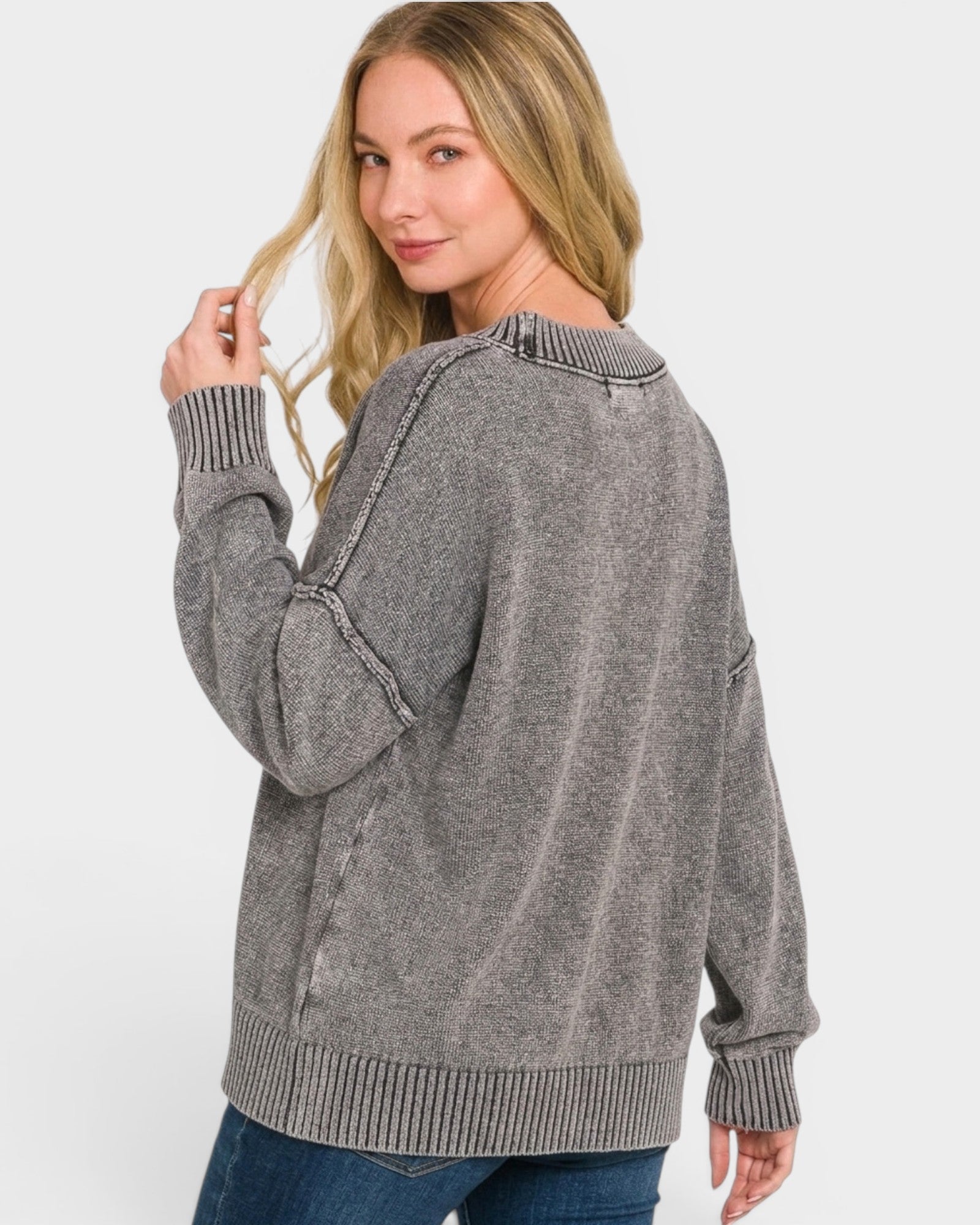 Woman wearing a gray sweater on a white background