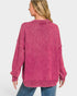 Person wearing a pink sweater on a plain background