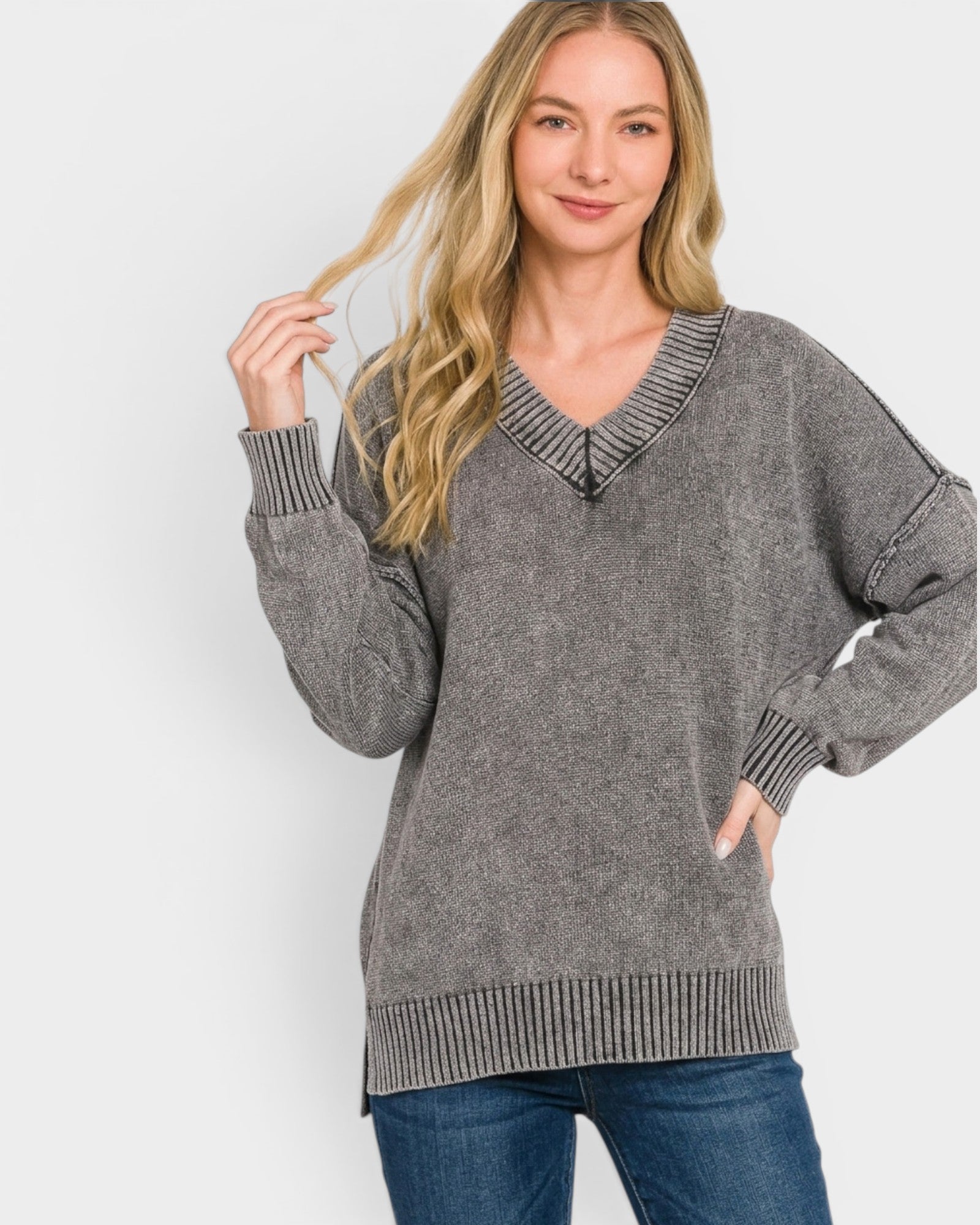 Woman wearing a gray sweater with a white background