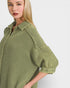 Woman wearing a green checkered shirt against a white background