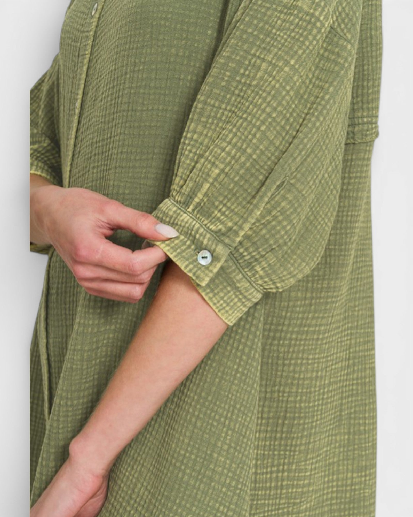 Green checkered shirt with a button on a white background