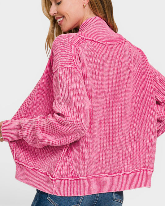Person wearing a pink knitted cardigan on a white background