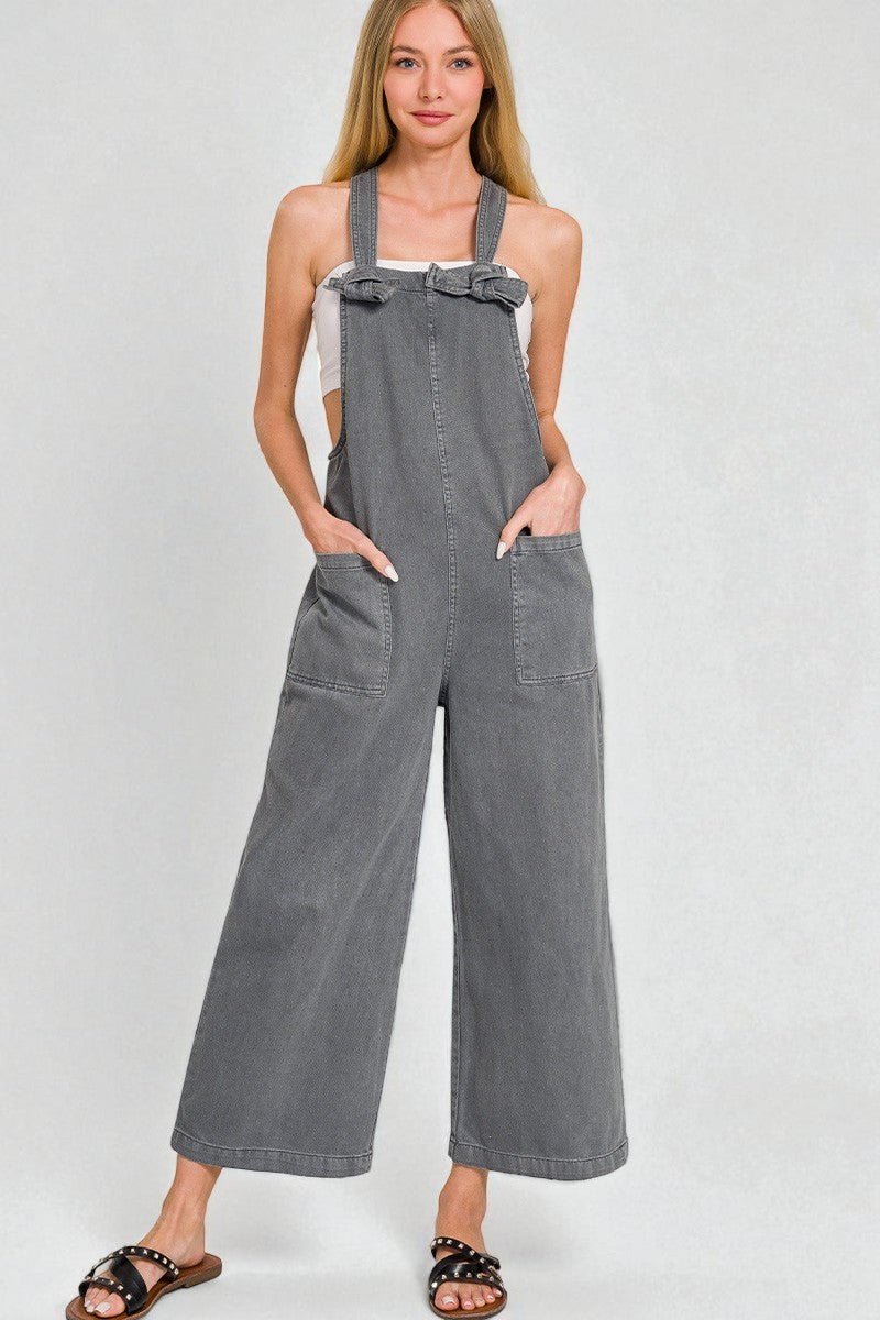 Woman wearing gray overalls on a white background