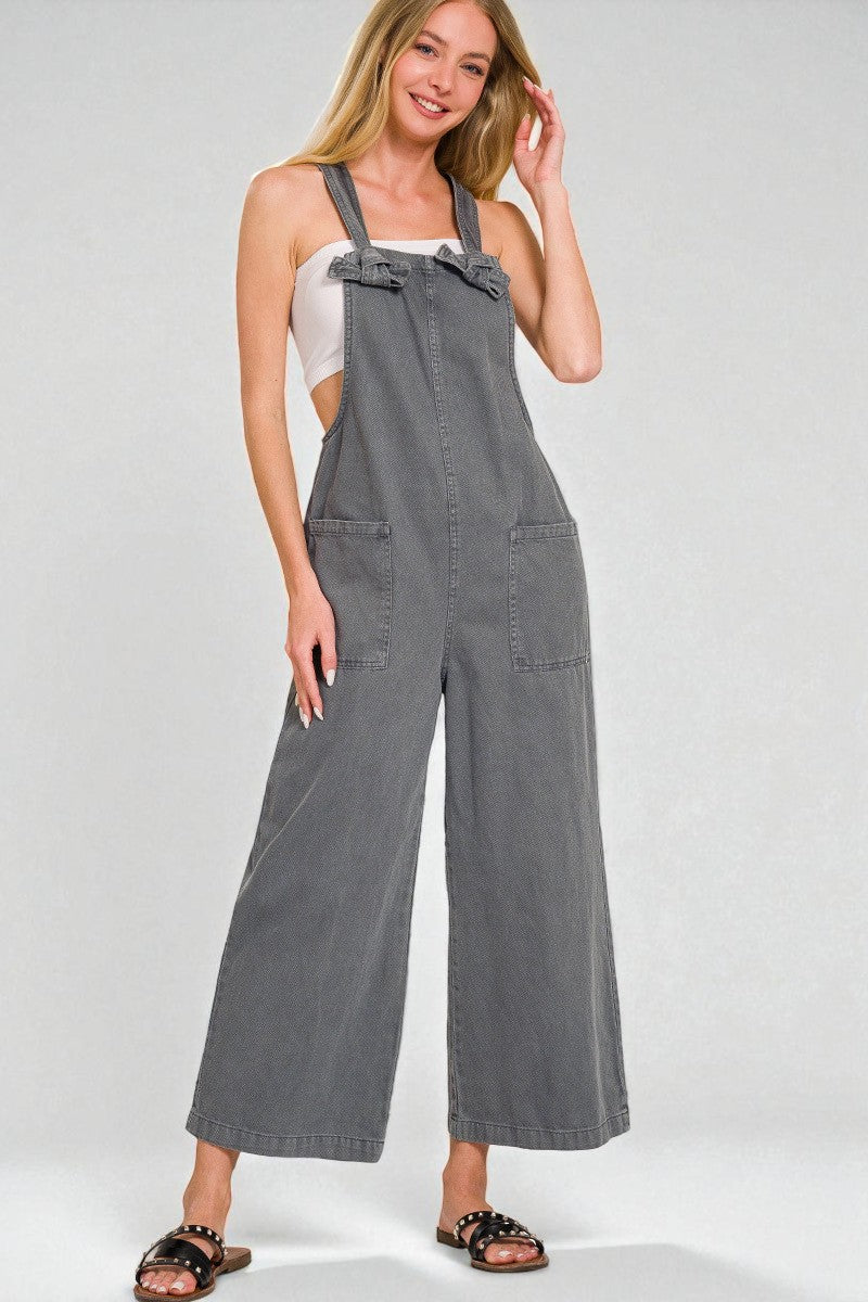 Woman wearing gray overalls on a white background