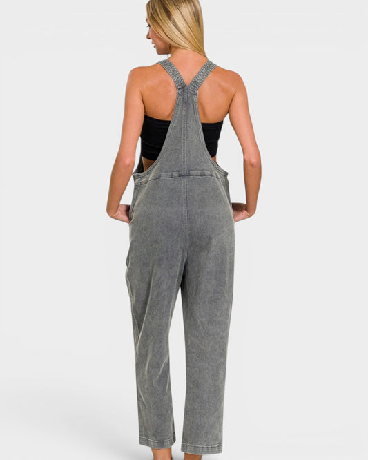 Person wearing gray overalls on a plain background