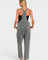 Person wearing gray overalls on a plain background