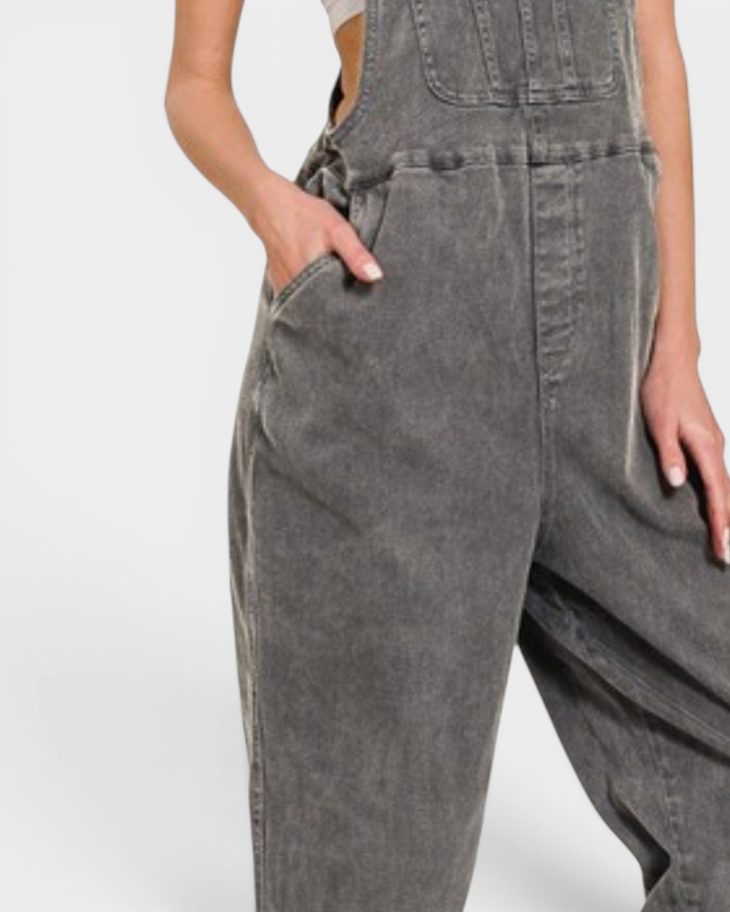 Gray denim overalls worn by a person on a white background