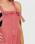 Pink denim pinafore dress on a plain background