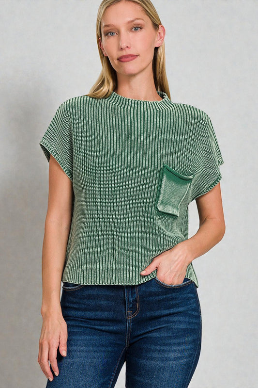 Woman wearing a green textured top with a pocket on a gray background