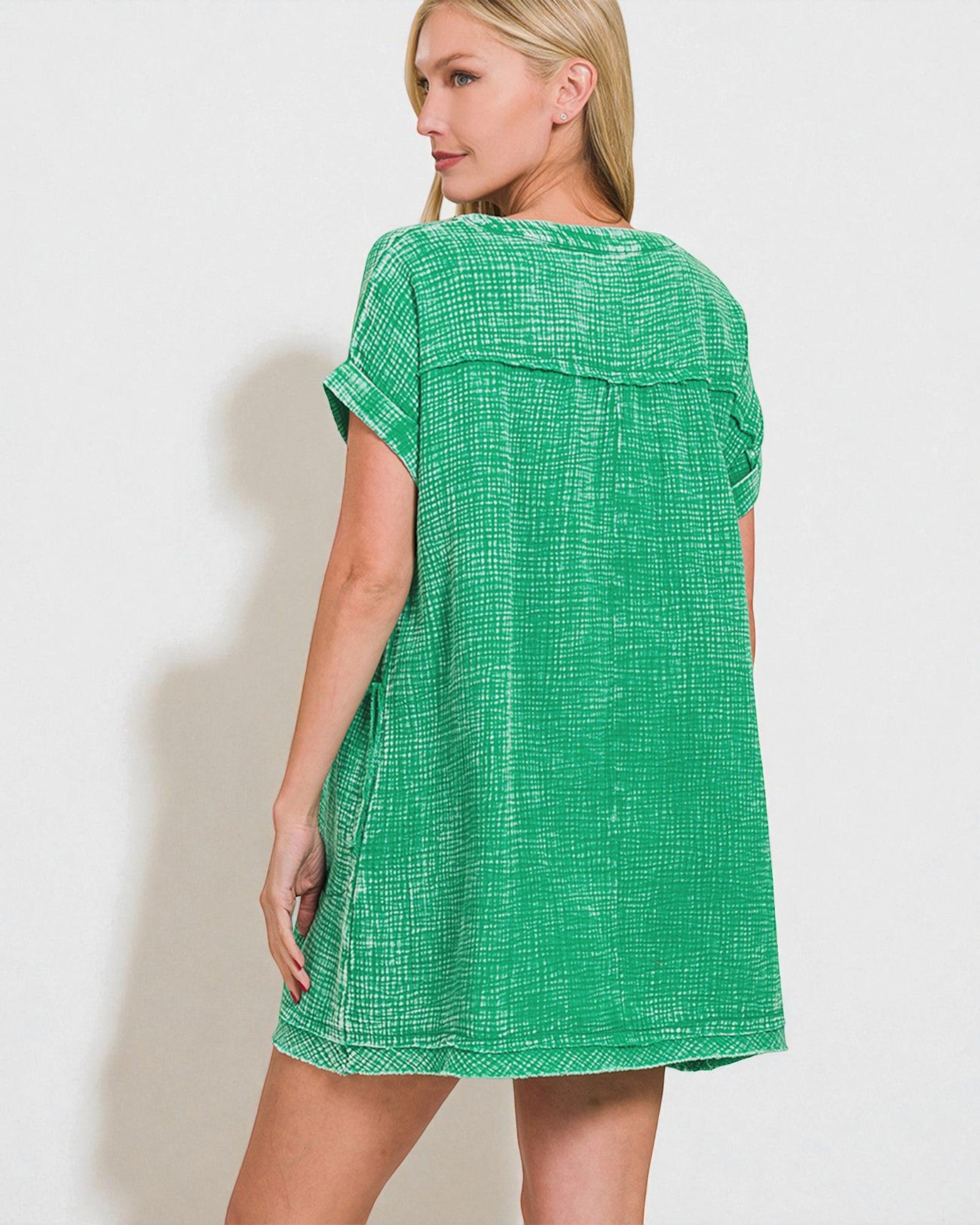Woman wearing a green checkered dress against a white background