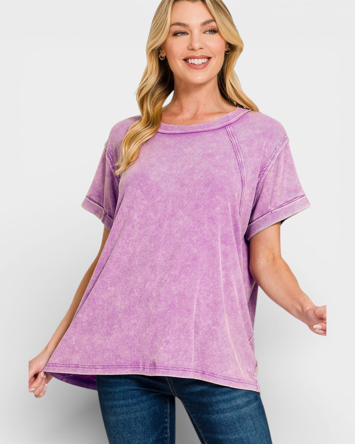 Woman wearing a purple t-shirt and blue jeans on a white background