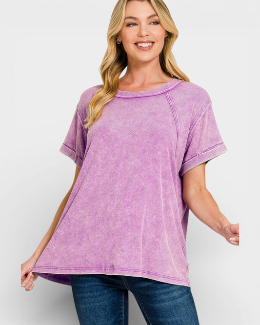 Woman wearing a purple t-shirt and blue jeans on a white background