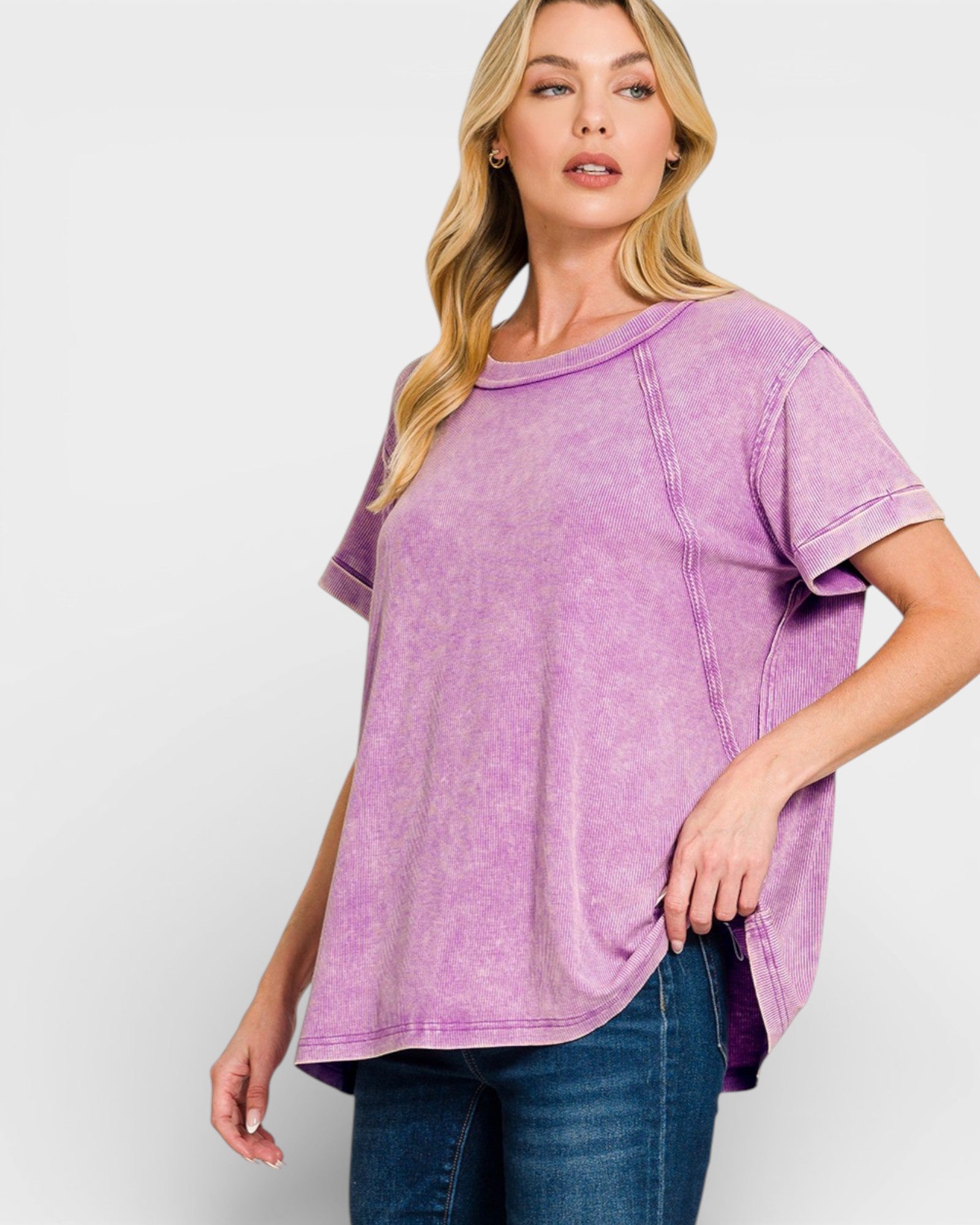 Woman wearing a purple t-shirt and blue jeans on a white background