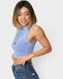 Woman wearing a blue ribbed crop top and jeans on a white background
