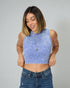 Woman wearing a blue sleeveless top and jeans on a gray background