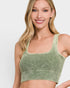 Woman wearing a green sports bra against a plain background