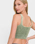 Woman wearing a green sports bra on a plain background