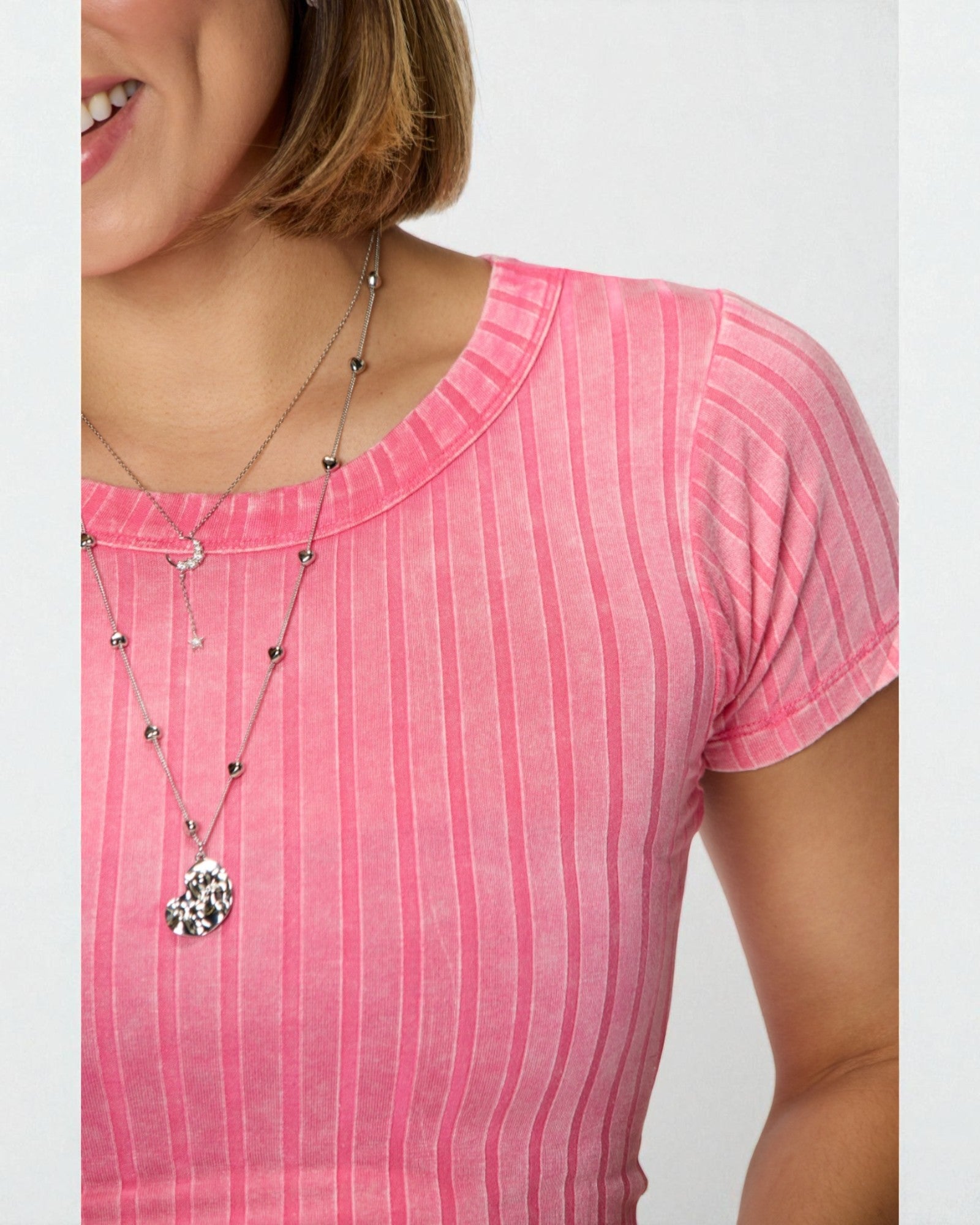 Person wearing a pink striped shirt with a necklace featuring a starfish pendant.