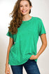 Woman wearing a green t-shirt and blue jeans against a plain background