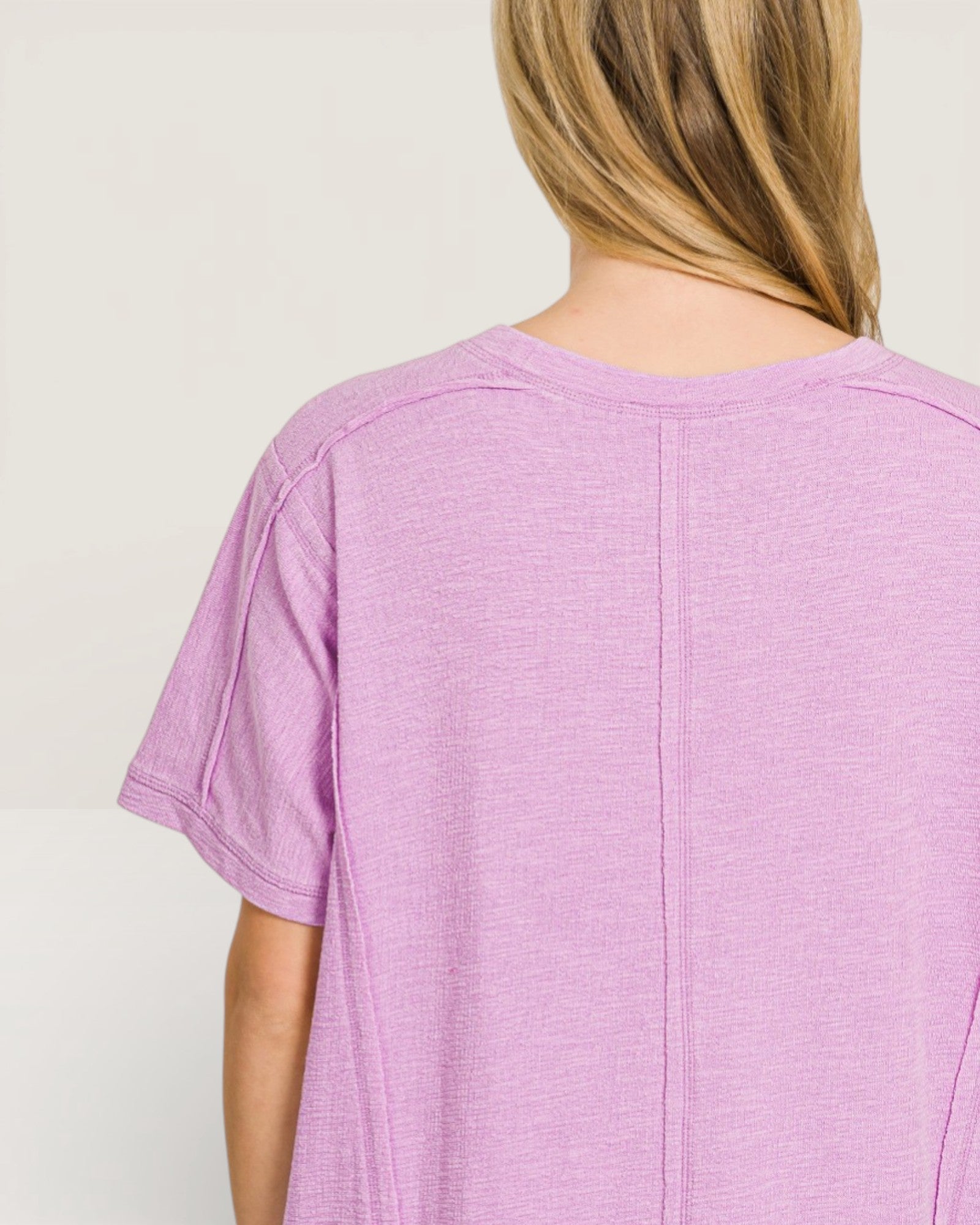 Person wearing a purple t-shirt against a plain background