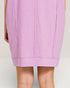 Close-up of a person wearing a light purple skirt on a plain background