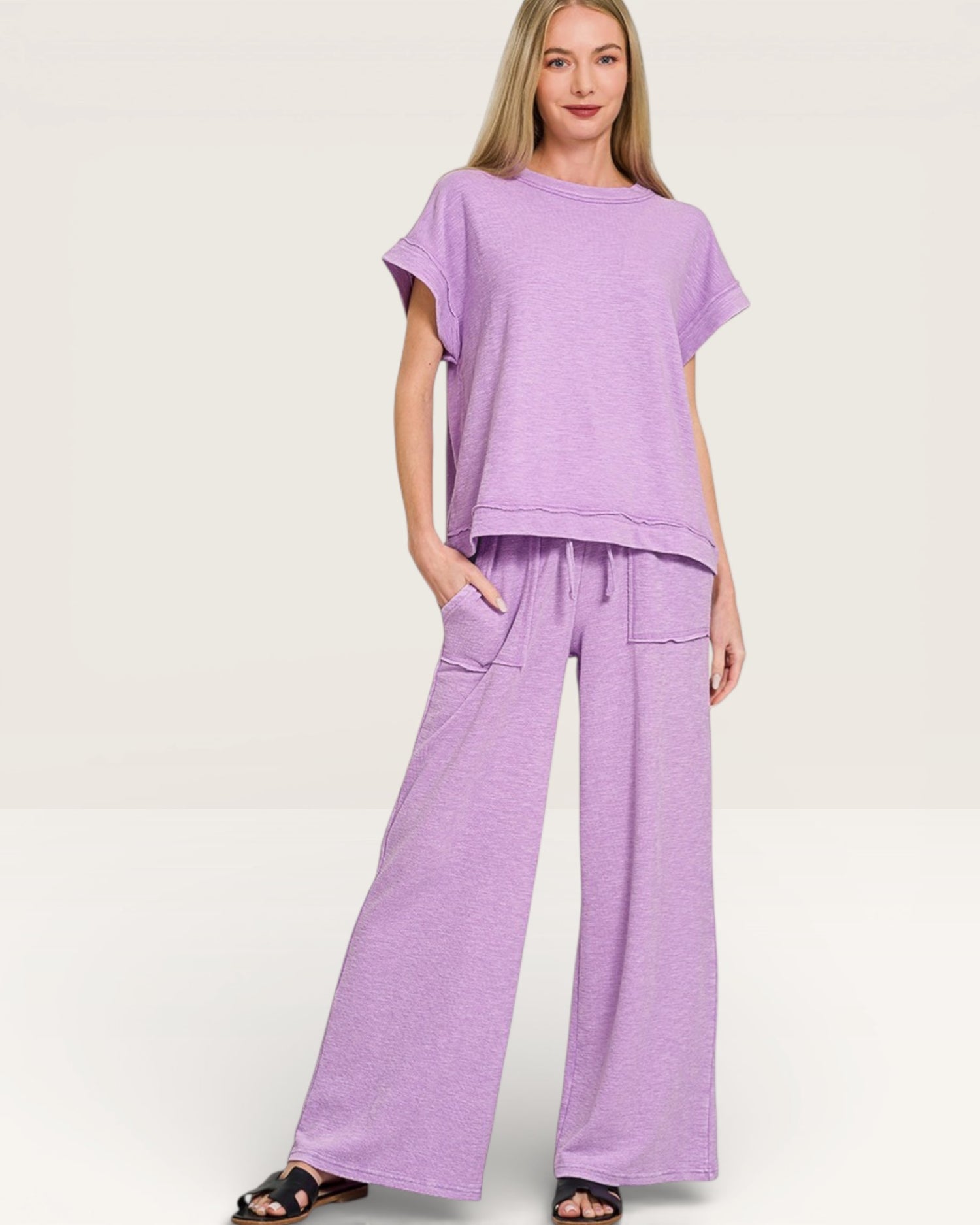 Woman wearing a purple outfit on a plain background