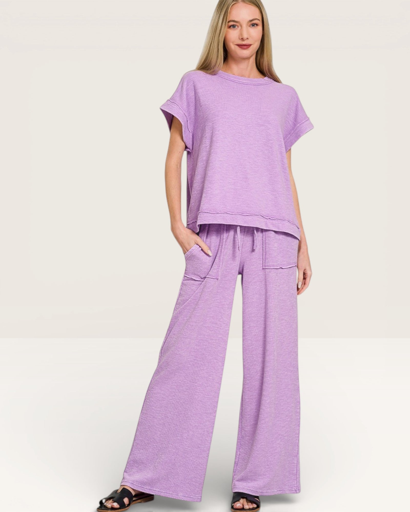 Woman wearing a purple outfit on a plain background