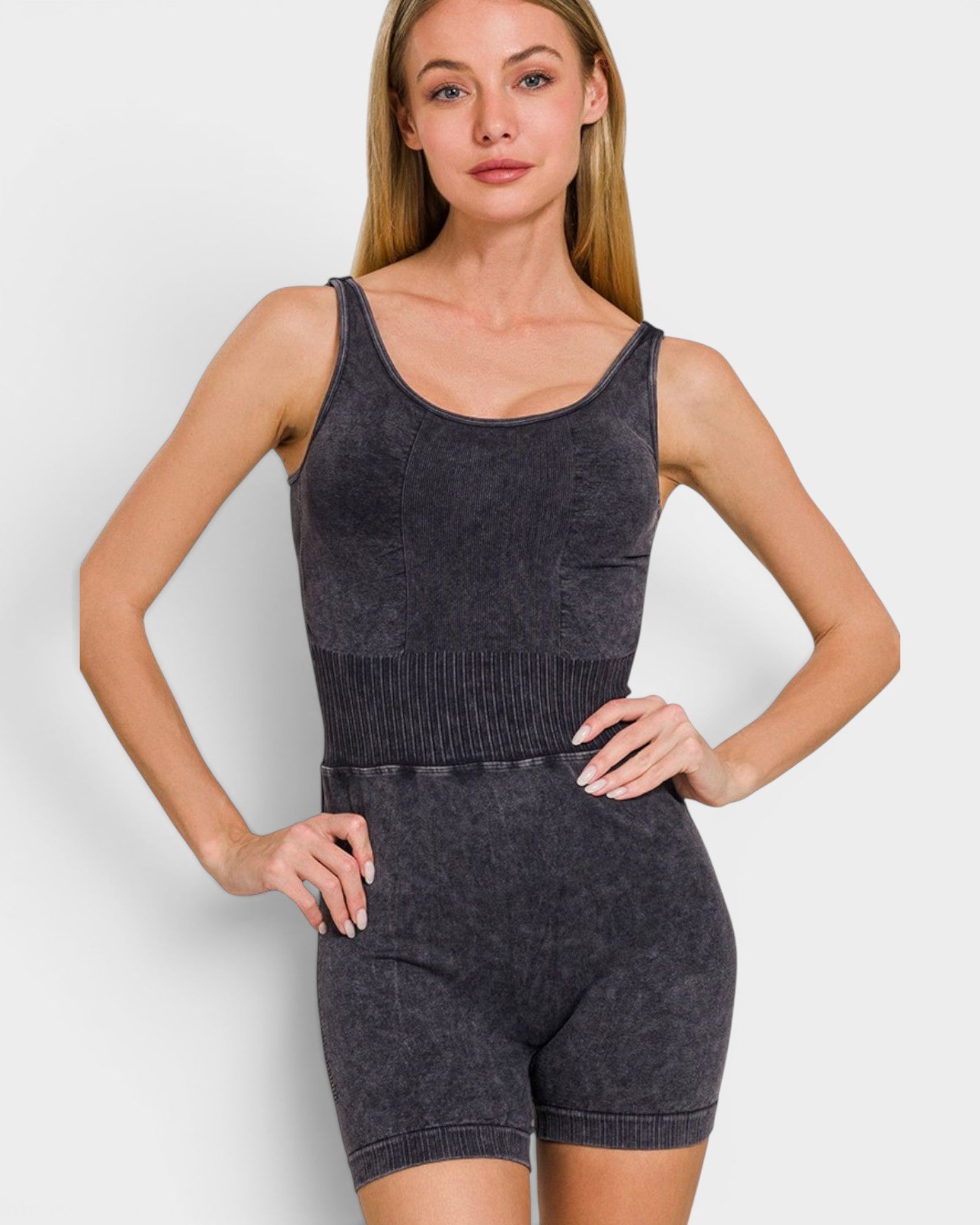 Woman wearing a dark gray knit romper on a white background