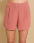Pink shorts worn by a person on a beige background