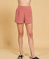 Person wearing pink shorts on a beige background