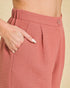 Close-up of pink pants with a button and pocket on a beige background