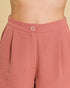 Close-up of pink pants with a button on a beige background