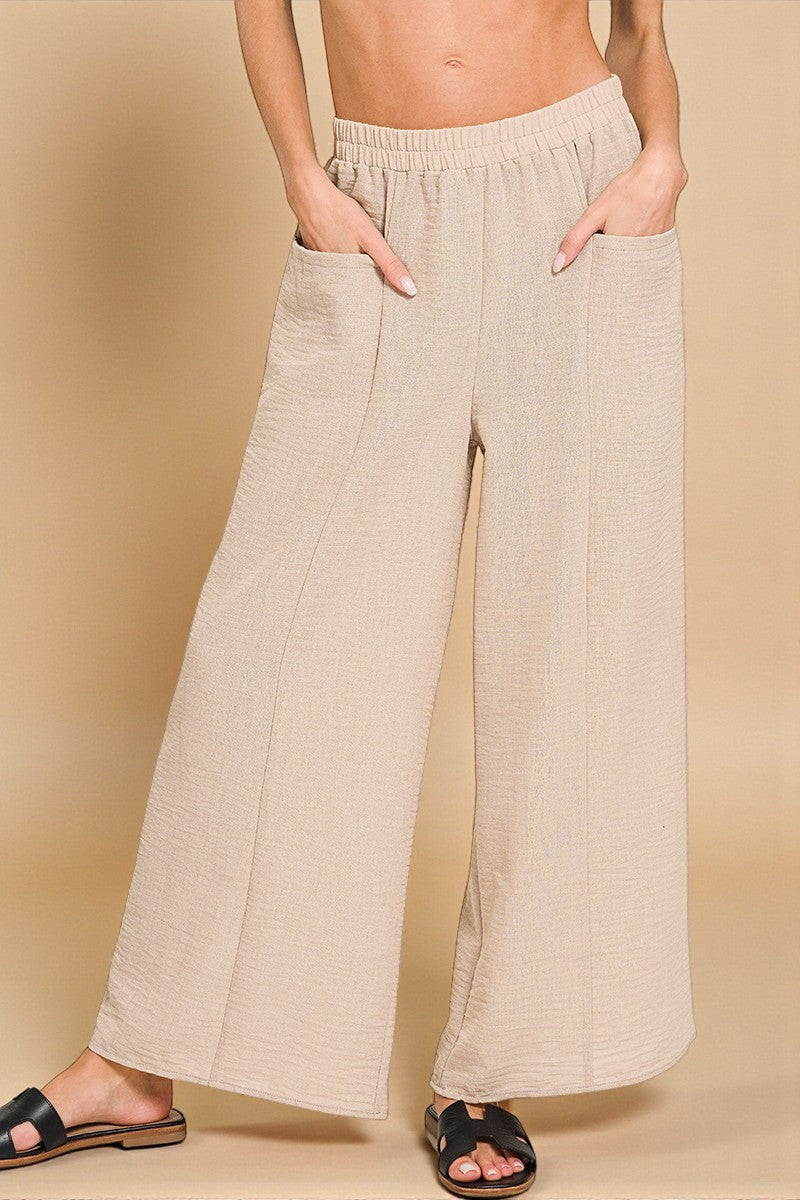 Beige wide-leg pants worn by a person on a beige background