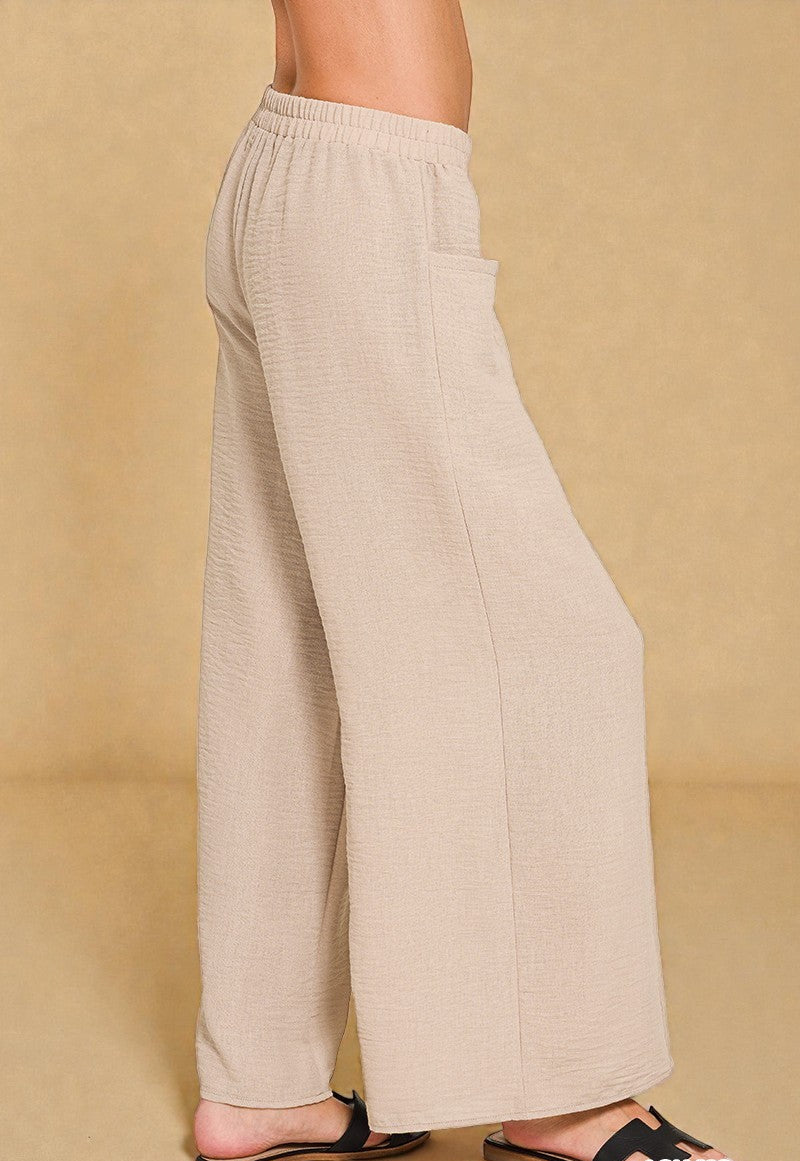 Beige wide-leg pants worn by a person on a beige background