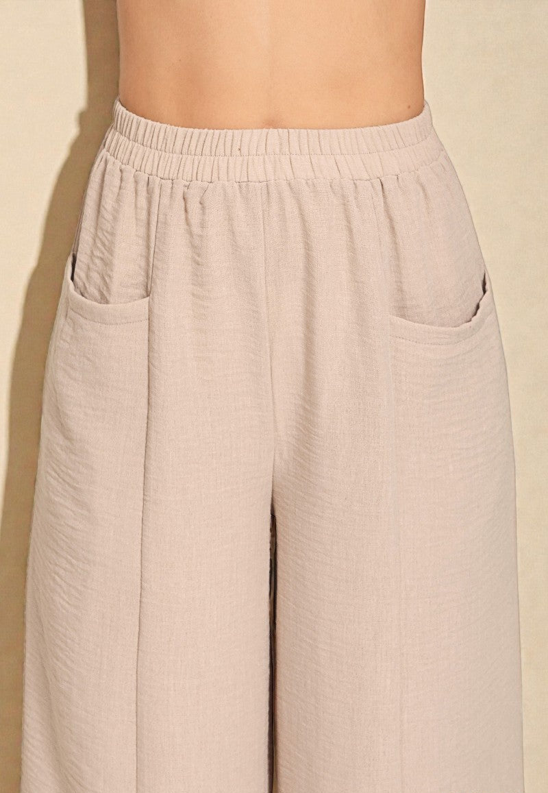 Beige wide-leg pants on a plain background with 'ASH MOCH' branding.