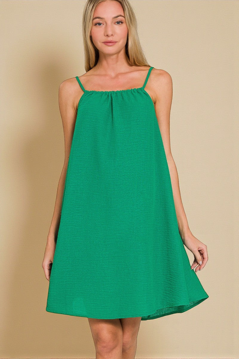 Woman wearing a green dress against a beige background