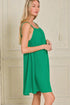 Woman wearing a green dress against a neutral background