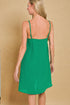 Woman wearing a green dress against a beige background